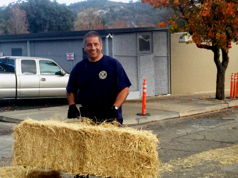 Albert Almodova, 2025 Champion of the Community, lifting a hay bale to help build the snow slide for the annual Atascadero Winter Wonderland event.