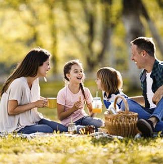 Happy family talking on a picnic in spring day. Copy space.