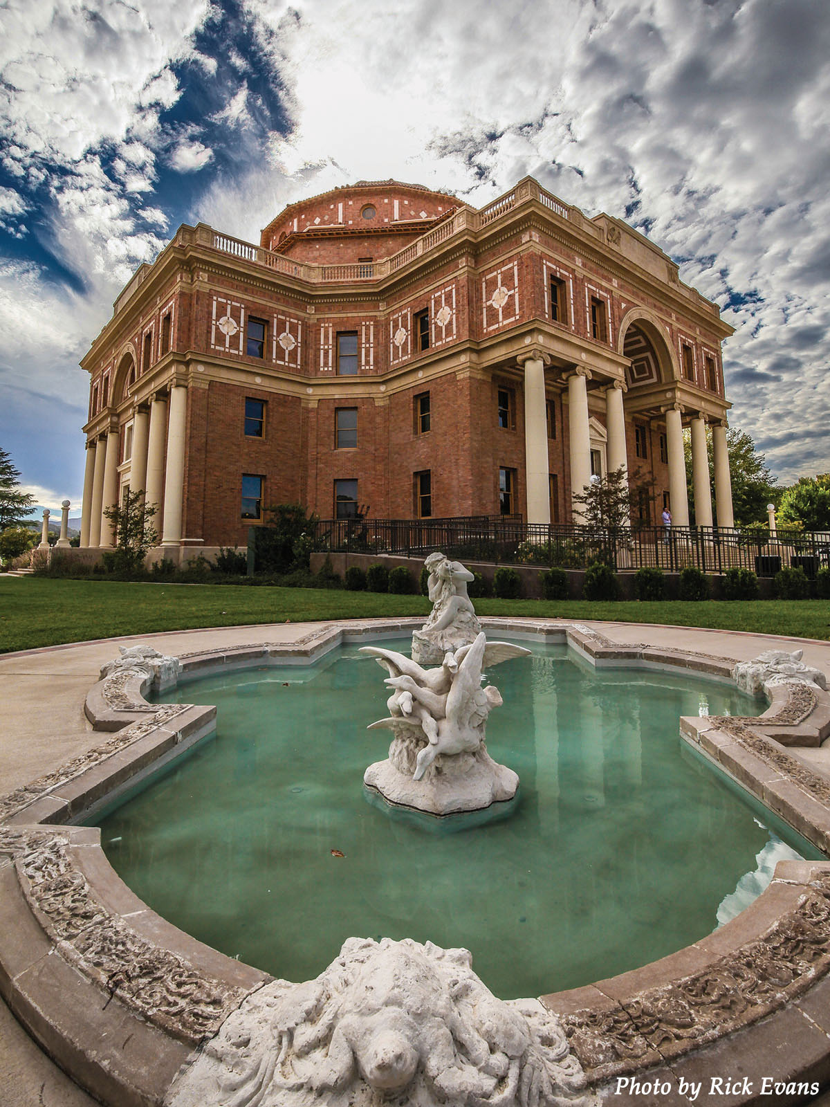 Up angle image of the Atascadero City Hall building against a blue sky with scattered clouds.