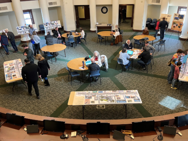 Image looking down on a group of people reviewing project information at an outreach meeting.