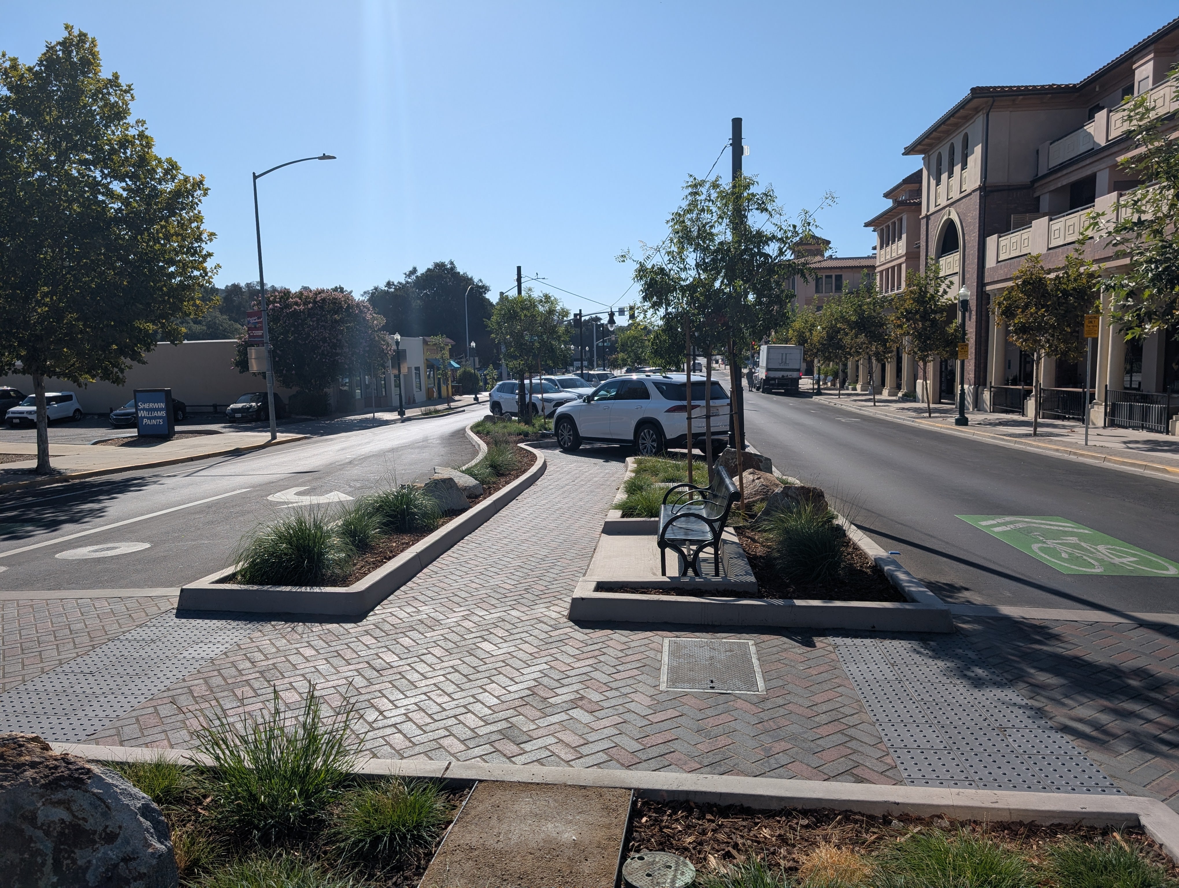 Southerly street view of El Camino Real at Entrada following completion of the Downtown Safety and Parking Enhancement Project, featuring new parking spaces, crosswalks, landscaping, and upgraded lighting.