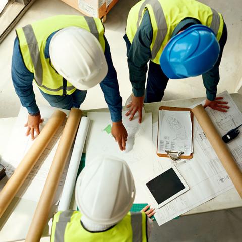 Several construction workers looking at blueprints