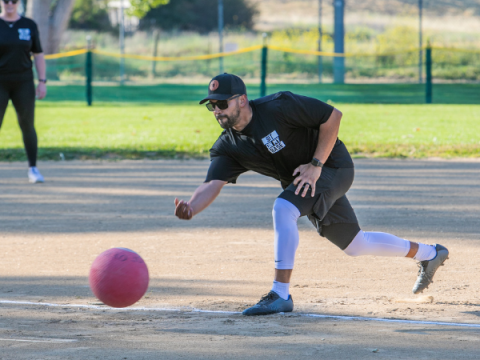 Man throwing ball during an adult kickball game.