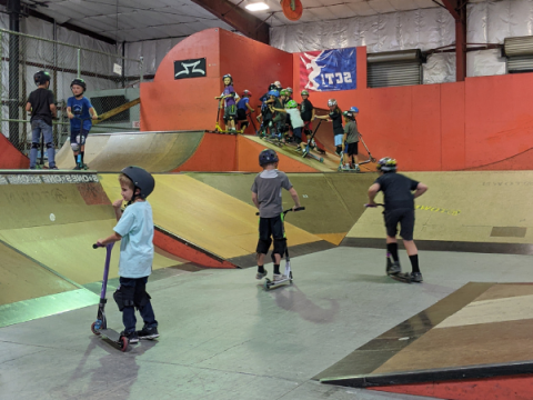 Young kids on scooters at the A-town skate park.