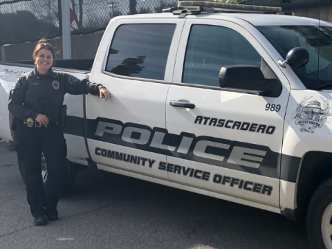 Officer standing in front of police vehicle.